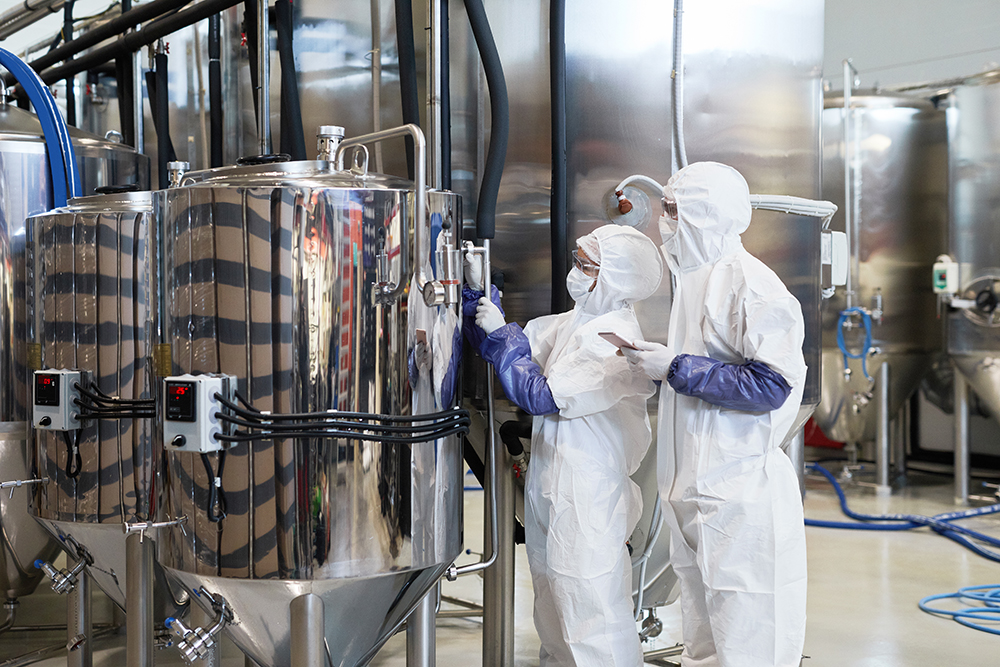 Two Workers Wearing Hazmat Suits at Chemical Factory